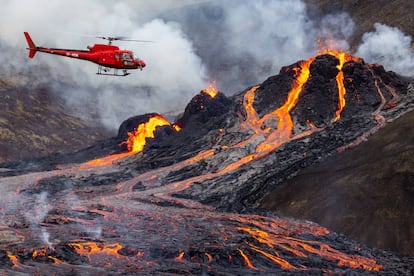 Un helicóptero sobrevuela la erupción del volcán, este domingo.