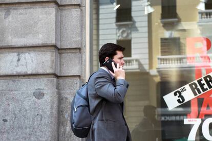 Un usuario habla por su móvil en una calle de Madrid.