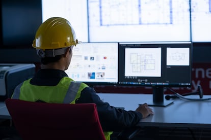 Industrial Engineering works in front of a monitoring screen in the control center. technology and AI concept.