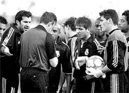 El árbitro Fernández Marín toma nota de la segunda tarjeta de Roberto Carlos ante Figo, el propio lateral brasileño, Celades y Casillas.
