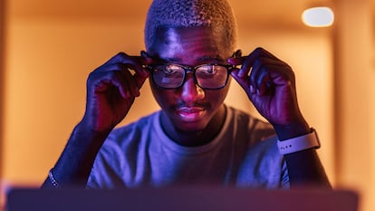 Un chico en una habitación con gafas de luz azul.