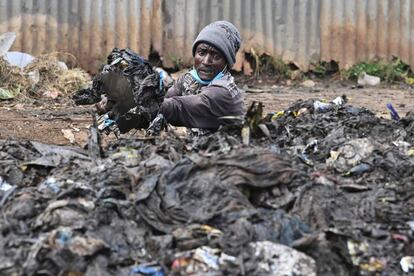 Un activista keniata desatasca un drenaje obstruido por la acumulación de basura, durante el Día Mundial del Medio Ambiente, en Riruta, Nairobi, Kenia.