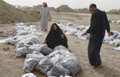 Familiares de las víctimas inspeccionan bolsas con restos de los cadáveres hallados en la fosa común de Mahawil, a 80 kilómetros de Bagdad.