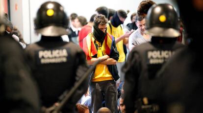 Agentes de los Mossos d'Esquadra controlan a los simpatizantes independentistas que han conseguido entrar en el T1 del Aeropuerto de El Prat.