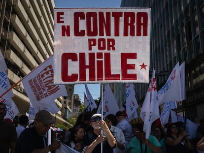 Un hombre sostiene un cartel a favor del voto en contra en el plebiscito constitucional, el 14 de diciembre.