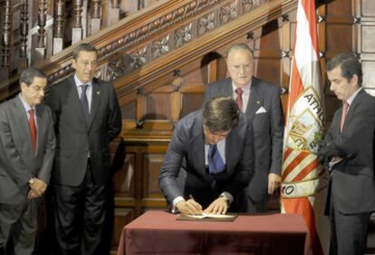 El presidente del Athletic, Fernando García Macua, firma el acuerdo en presencia de Mario Fernández (presidente de BBK), José Luis Bilbao (diputado general de Vizcaya) e Iñaki Azkuna (alcalde de Bilbao).