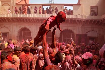 Un hombre se divierte con su hijo durante las celebraciones en la ciudad india de Vrindavan.