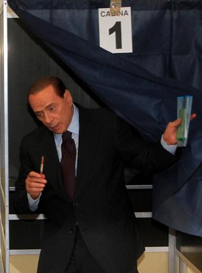 El primer ministro italiano, Silvio Berlusconi, sale de la cabina de votaciones de un colegio electoral de Milán (Italia).