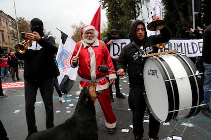 Un manifestante disfrazado de Papá Noel asiste las manifestaciones en Santiago de Chile de este miércoles.