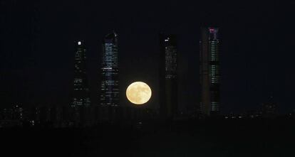 La superlluna entre les quatre torres de la Castellana, fotografiada des d'Aravaca, Madrid.