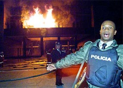 Un policía colabora en la extinción del fuego declarado en Parlamento de Ecuador.