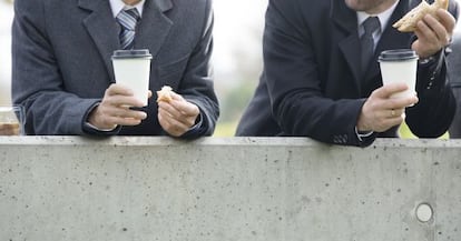 Dos trabajadores hacen un receso para tomar un refrigerio. 