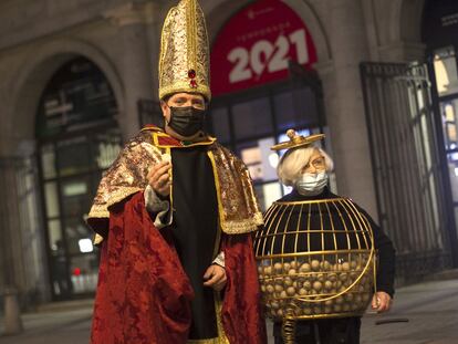 Juan Manuel López y Manoli, disfrazados de obispio y bombo, ante las puertas del Teatro Real de Madrid, este martes.