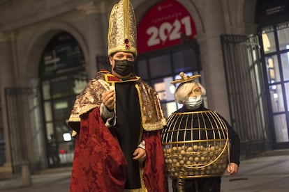 Juan Manuel López y Manoli, disfrazados de obispio y bombo, ante las puertas del Teatro Real de Madrid, este martes.
