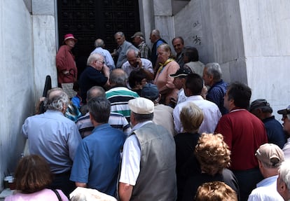 Un grupo de pensionistas que cobran sus pensiones a final de mes, hacen cola a las puertas de una oficina bancaria en la ciudad griega de Salónica, el 29 de junio de 2015.