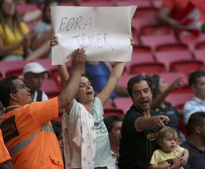 Apesar da liberação pela decisão judicial, segurança tenta retirar cartaz "Fora Temer" de torcedora no estádio Mané Garrincha.