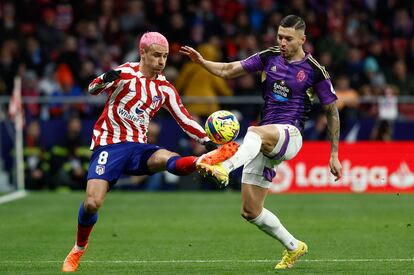 Antoine Griezmann en una acción con Javier Sánchez durante el partido de la Liga entre el Atlético de Madrid y el Valladolid, en el Metropolitano este sábado.