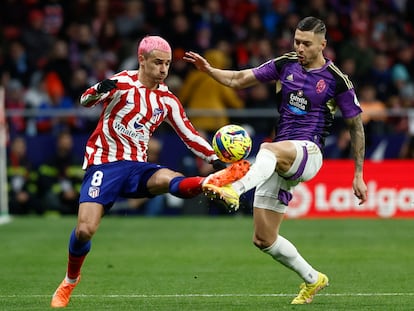 Antoine Griezmann en una acción con Javier Sánchez durante el partido de la Liga entre el Atlético de Madrid y el Valladolid, en el Metropolitano este sábado.