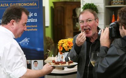 El crítico gastronómico Rafael García Santos come un pincho de chistorra en presencia del cocinero Martín Berasategui.