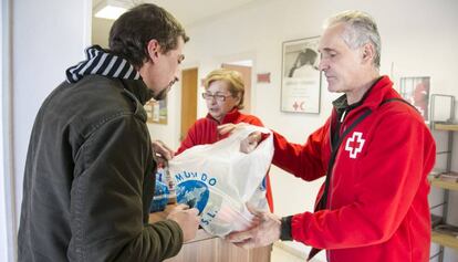 Un usuari rep aliments de la Creu Roja, en una imatge d'arxiu.