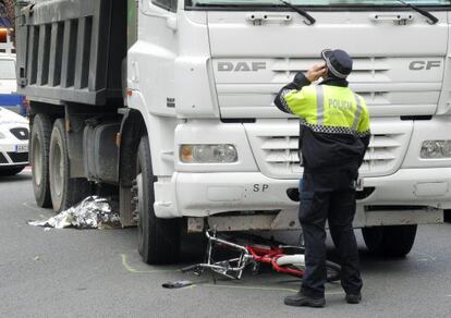 Un policía, en el lugar del accidente donde ha fallecido una ciclista, antes del levantamiento del cadáver