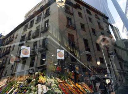 Puesto de frutas y verduras tras la fachada de cristal del renovado mercado de San Miguel.