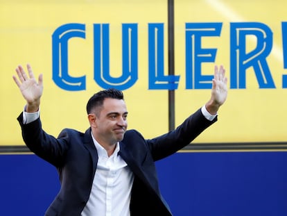 El nuevo entrenador del FC Barcelona, Xavi Hernández, saluda a los aficionados que se han citado en las gradas del Camp Nou para asistir al acto de presentación.