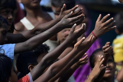 Varios niños esperan a recibir paquetes de galletas tras las inundaciones en el distrito de Morigaon, en el estado de Assam (India). Según los medios locales, al menos 10 personas han muerto y el número de afectados en el estado alcanza los 1,2 millones.