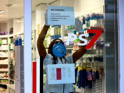 Una farmacéutica cuelga un cartel donde avisa que no le quedan mascarillas ni geles desinfectantes en Platja d'Aro (Girona).