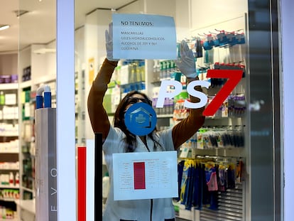 Una farmacéutica cuelga un cartel donde avisa que no le quedan mascarillas ni geles desinfectantes en Platja d'Aro (Girona).