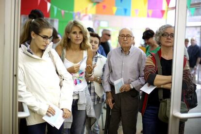 Els col·legis electorals han obert a les 9.00 i tancaran a les 20.00. A la imatge, diverses persones esperen el seu torn per votar a l'Eixample de Barcelona.