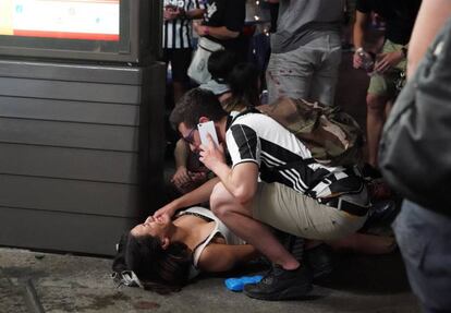 Un hombre atiende a una mujer herida durante la estampida en la plaza de San Carlo, en Turín, el sábado