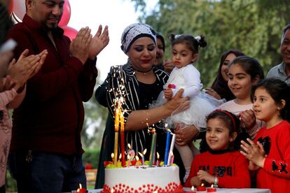 Una familia iraquí celebra el cumpleaños de una hija en el jardín del parque de diversiones Al-Zawra en Bagdad (Irak), el 15 de marzo de 2019.