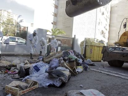 Trabajadores de los servicios m&iacute;nimos y una retroexcavadora de Tragsa trabajan en la recogida de basura.