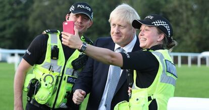 El primer ministro británico, Boris Johnson, se fotografía con dos policías en un acto el pasado viernes.