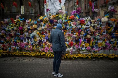 Un hombre observa el mural con fotografías y flores que  conmemora a los fallecidos en la guerra en la ciudad de Lviv, en el oeste de Ucrania. 
