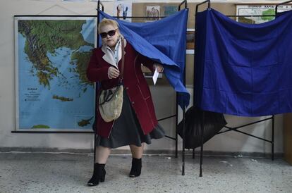 Una dona surt d'una cabina abans de votar en una mesa electoral d'Atenes.