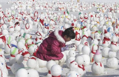 Una niña rodeada de cientos de muñecos de nieve durante el festival de hielo en Hwacheon, Corea del Sur, en enero de 2014.