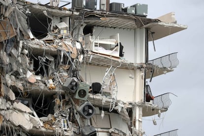 Objetos y escombros cuelgan de una sección del condominio Champlain Towers South, tras el derrumbe parcial del edificio, en el área de Surfside de Miami.