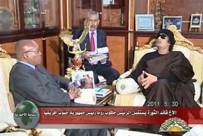 Gadafi (derecha), reaparece en público y se deja grabar por la televisión estatal libia durante su encuentro con el presidente surafricano.