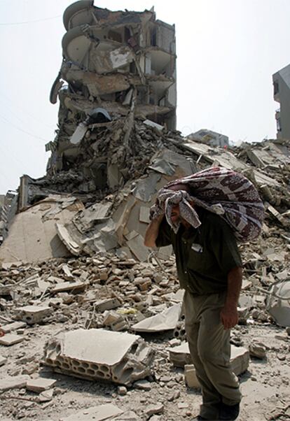 Un libanés pasa ante un edificio bombardeado en un suburbio del sur de Beirut.