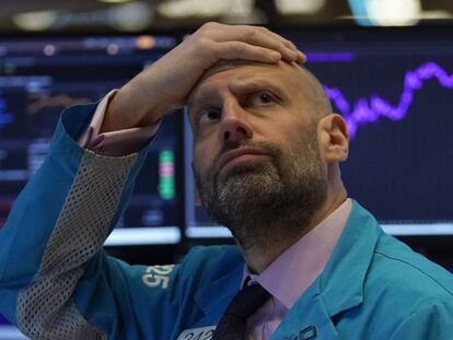 Un administrador de mercado mira las pantallas de valores en Wall Street.