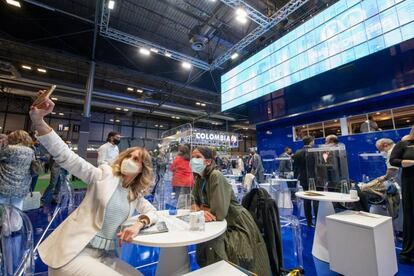 Participantes de Fitur se toman un selfi en un estand de la feria.