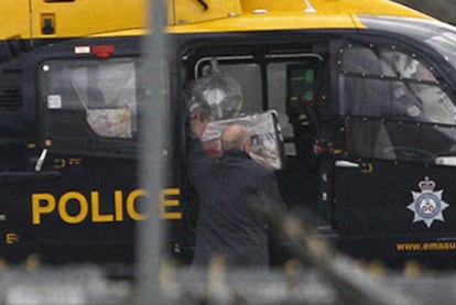 La policía británica transporta en un helicóptero el paquete sospechoso hallado en un aeropuerto al norte de Londres.