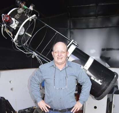 Víctor Buso frente a su telescopio en su casa de Rosario, Argentina.