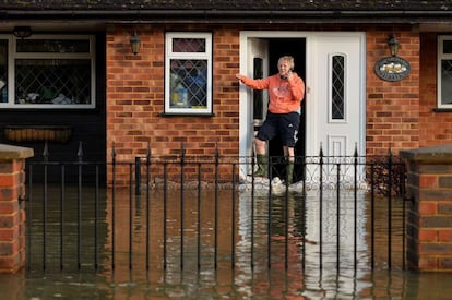 Un vecino de Wraysbury habla por teléfono desde la puerta de su casa. El desbordamiento del río Támesis ha causado inundaciones en a localidad y muchos de sus residentes han teneido que ser evacuados.