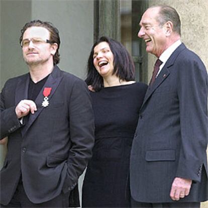 El cantante Bono, condecorado ayer en París, con su esposa, Ali, y Chirac.