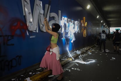 Manifestantes rompen las luces de una publicidad de la cadena estadounidense de supermercados Walmart durante el recorrido de la protesta. 