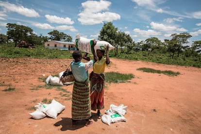Dos mujeres cargan con una bolsa de alimentos en el pueblo africano de Simumbwe, en Zambia. 