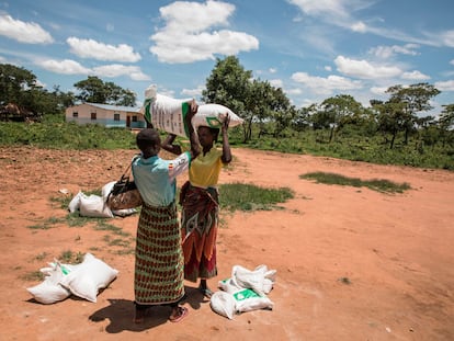 Dos mujeres cargan con una bolsa de alimentos en el pueblo zambiano de Simumbwe.